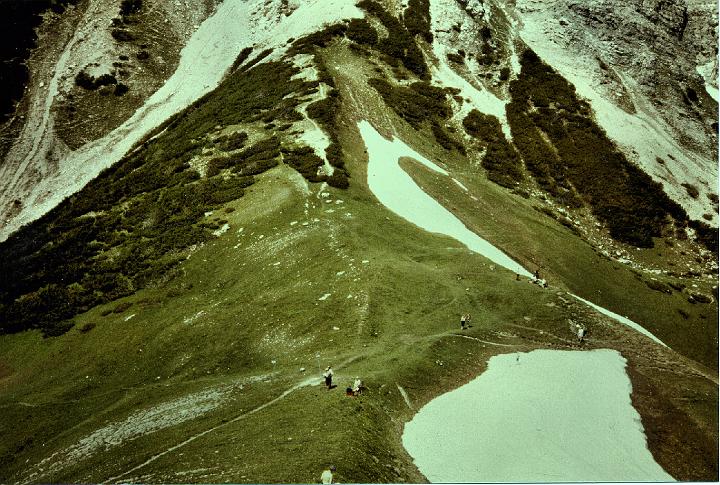 br81_amat_joch_b.jpg - The ridge of the pass (Joch) where we were having our lunch the first time we were there. There was so much snow that year again (1981) that people were skiing on short skis down the mountain that you can just see the beginning of at the back of this picture.