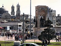 Istanbul - bus tour  Republic Monument at Taksim Square, the northern end of İstiklal Caddesi. The towers and dome on the left are the Greek Orthodox church, Aya Triada Kilisesi