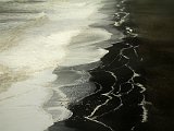 Sea foam on the black-sand (and pebble) beach at Dyrhólaey